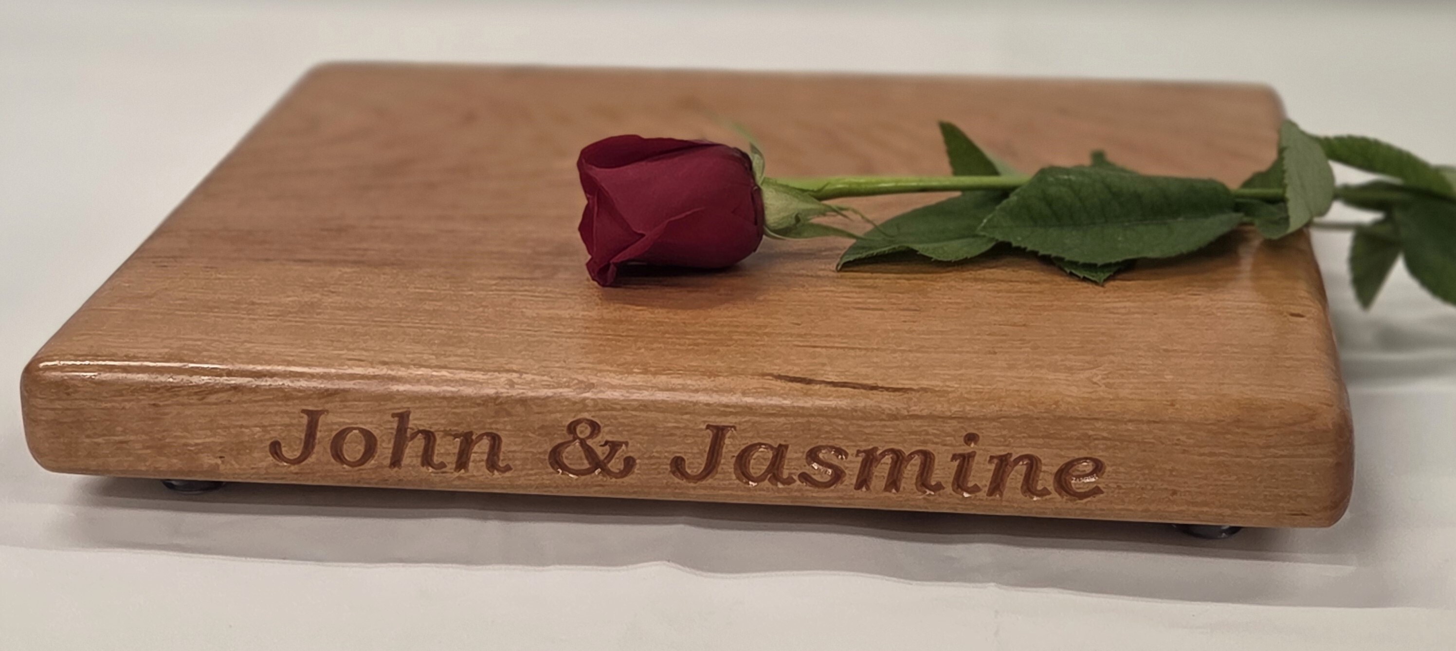 cherry cutting board by Treeboard engraved with "John & Jasmine"